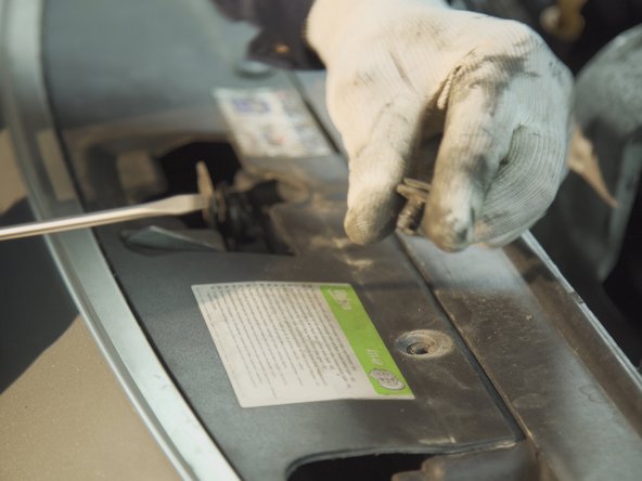 A l'aide d'un tournevis plat, faites levier sur l'agrafe de fixation du pare-choc pour la retirer