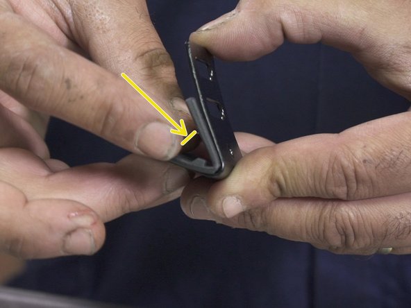 Plier en deux les accroches en caoutchouc puis les placer dans les boucles