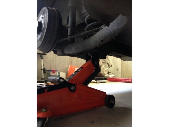 À l'aide d'un cric, soulever légèrement le train arrière sous le ressort pour soulager la pression.