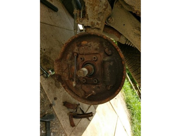 Décrocher le câble du frein à main en le poussant vers le haut