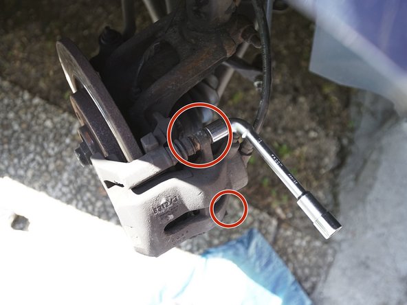 Retirez les deux vis de l'étrier à l'aide d'une clé plate de 13 et d'une clé à pipe de 13