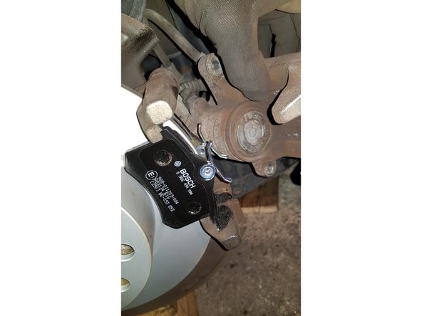 Positionnez les 2 plaquettes sur le support d'étrier puis retirez les feuilles en papier.