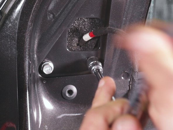 Al'aide d'un petit cliquet et d'une douile de 10 desserrer les trois vis retenant le rétroviseur