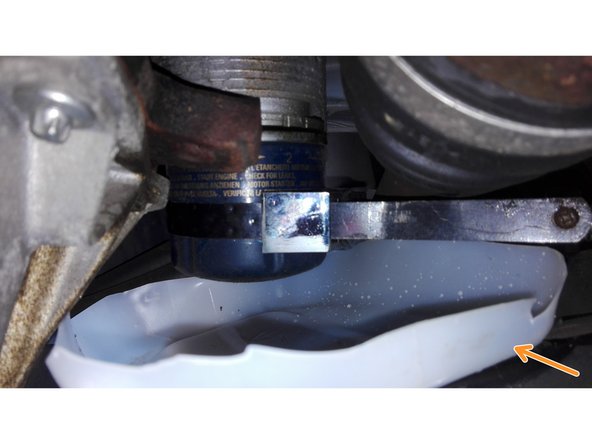 Le filtre à huile étant situé juste au dessus du berceau du véhicule, il est préférable de placer un récipient en dessous de ce filtre afin de ne pas laisser couler l'huile sur le berceau. utiliser par exemple un fond de bidon de liquide de refroidissement, puis dévisser entièrement le filtre en attendant qu'un maximum d'huile ne tombe (photo 2 )