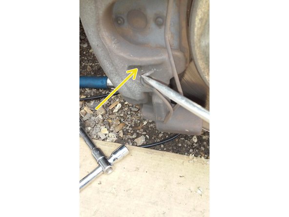 Avec un tournevis plat pousser la pointe de l'agrafe du bas dans son trou,maintenez la avec votre pouce en même temps que vous poussez.