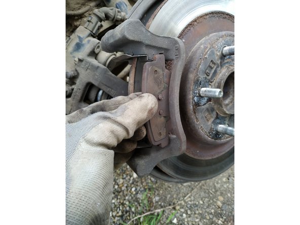 Dégagez la plaquette avant en la faisant glisser vers vous. Dégagez la plaquette arrière en la poussant vers la voiture
