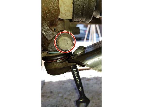 Avec une clé à œil de 17mm et d'un embout Torx mâle T50 retirez la vis qui maintient la rotule de suspension dans la fusée.