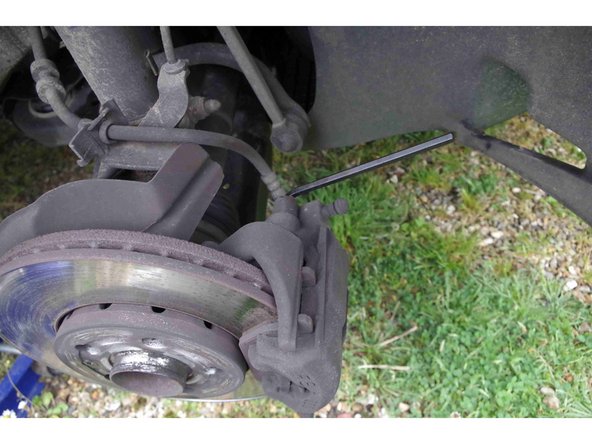 Pour démonter l'étrier, il faut dévisser 2 colonnettes. Elles sont protégées par un capuchon en plastique qu'on dégage aisément avec un tournevis à bout plat (toujours le même si vous suivez).