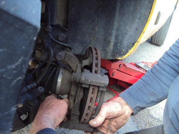 Démontez le porte-étrier en dévissant les 2 vis de part et d'autre avec une clé de 19mm (ou clé de 3/4)