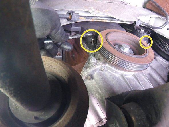 Faire pivoter la biellette du berceau  pour accéder aux vis du bas du carter en plastique