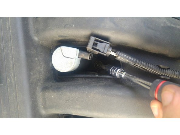 Sous l'emplacement d'origine du câble, la bobine est tenue par une Vis de type Torx, il faut l'enlever à l'aide d'un tournevis