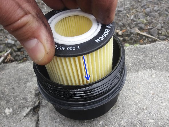 Le côté du filtre avec un ergot en plastique qui dépasse est celui qui se clipse au fond de la cloche.