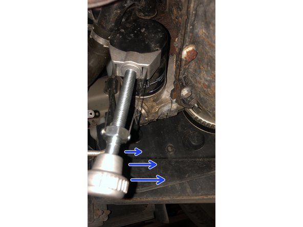 Pendant que l'huile s'écoule, placer la clé à sangle sur l'ancien filtre pour le desserer