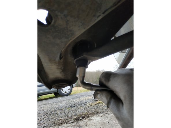 On peut compresser le triangle et la barre stabilisatrice à la main pour mettre au jour les filets de la vis.