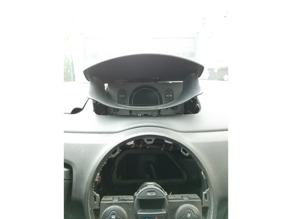 Deviser la vis de fixation de la visière du combiné d'instrument puis déposer celle-ci.