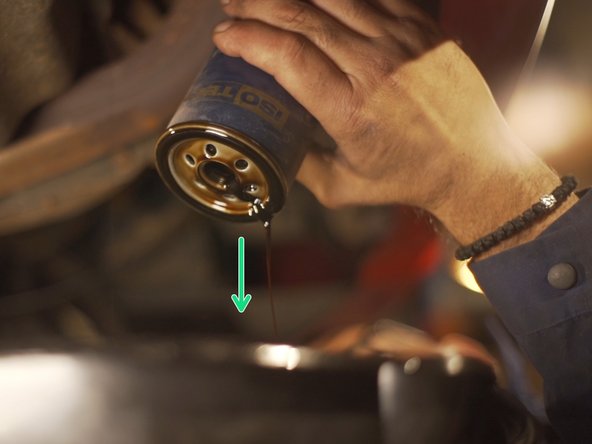 
Remove the oil filter by hand and let the oil drain into the basin
