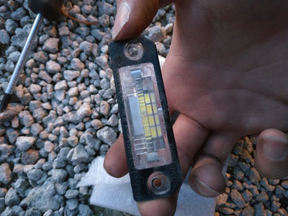 Tirer délicatement sur l'ampoule pour la sortir de deux lamelles métalliques (utiliser un chiffon)