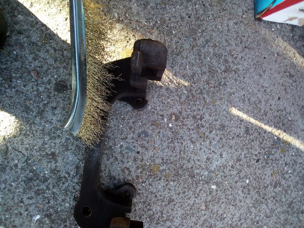 Profitez-en pour nettoyer à l'aide d'une brosse métallique l'étrier et le support.