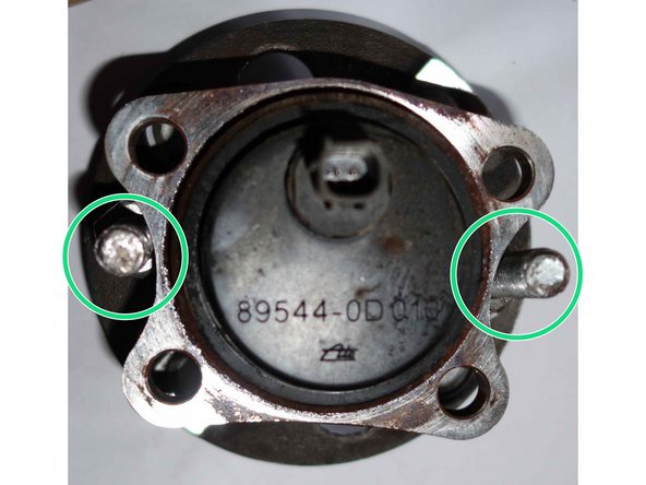 Le bas de la vis, vient tangenter le bord concave extérieur du support de fixation du roulement de moyeu.