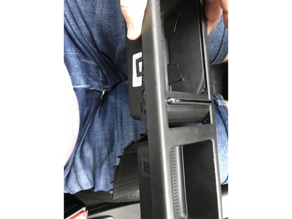 On enfile le nouveau rideau par derrière, en fermant le vide poche jusqu’au bout.