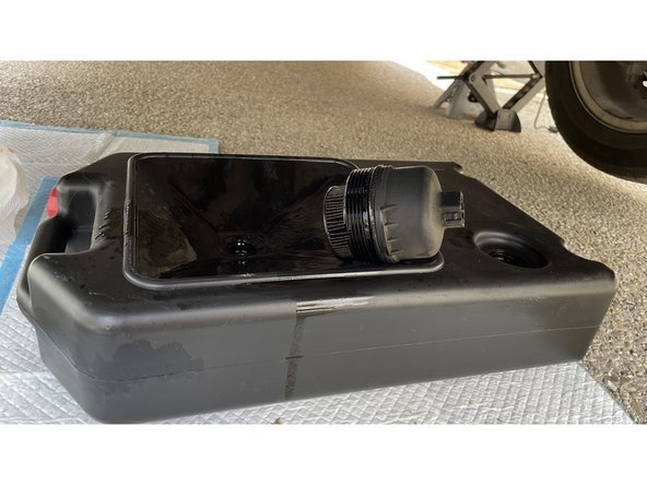 Je dépose le filtre à huile et le place dans le bac de récupération.