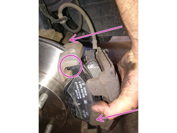 Présenter l'ensemble sur le nouveau disque, vérifier le bon positionnement du crochet  des deux plaquettes (rond rose sur la photo 3)