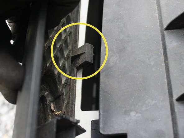 Placer d'abord les crochets de la partie inférieur de la calandre.