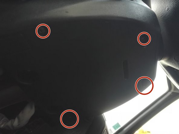 Dévisser les 4 vis de fixation de la demi coquille inférieure sous le volant, puis la déposer