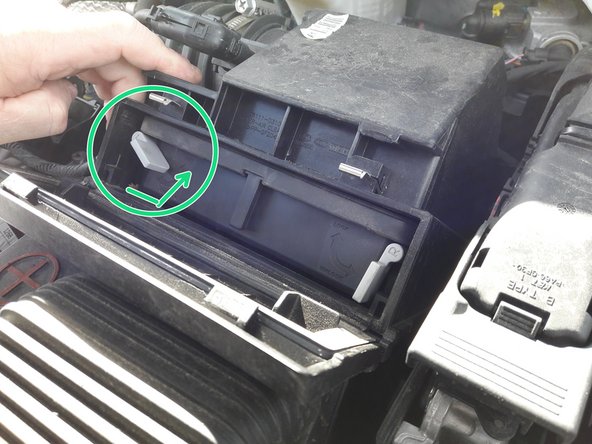 Une fois le filtre à air au fond de la boite à air, faites pivoter avec votre doigt le clips de blocage gauche vers le haut