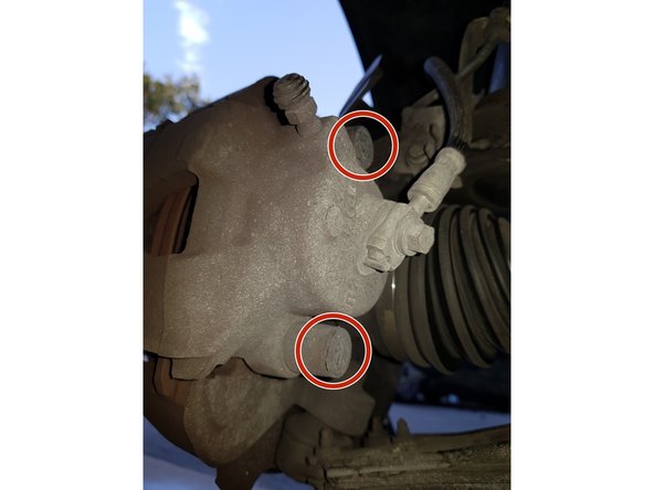 Avec un petit tournevis plat retirez les capuchons des vis d'étrier.