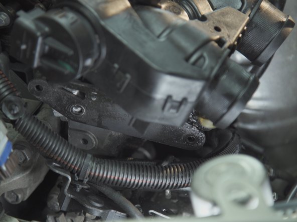 Dévisser les deux écrous présents sous la plaque précédemment retirée avec un cliquet et une douille de 13