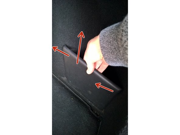 Sortir le revêtement de coffre en le dégrafant : tirer vers le haut et vers l'intérieur du coffre