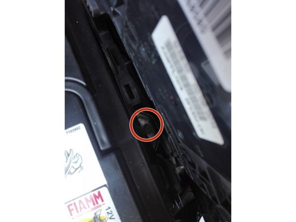 A l'aide du cliquet de 10mm et de la rallonge dévisser le boulon qui maintient la batterie.