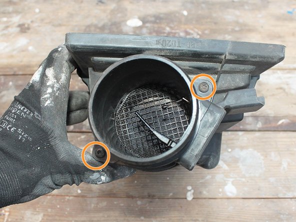 Dévisser  à l’aide d’un tournevis torx T20 les 2 vis qui maintiennent le débitmètre sur le couvercle de boite à air.