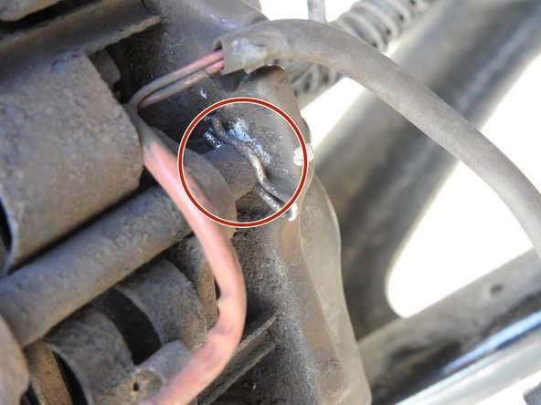 Une fois les pistons rentrés, les plaquettes doivent bouger, il faut maintenant retirer l’axe en métal qui traverse les deux plaquettes et qui maintient la plaque de maintien (désolé pour les termes mais je ne suis pas du métier). Pour retirer celui, il faut d’abord retirer la goupille avec une pince.