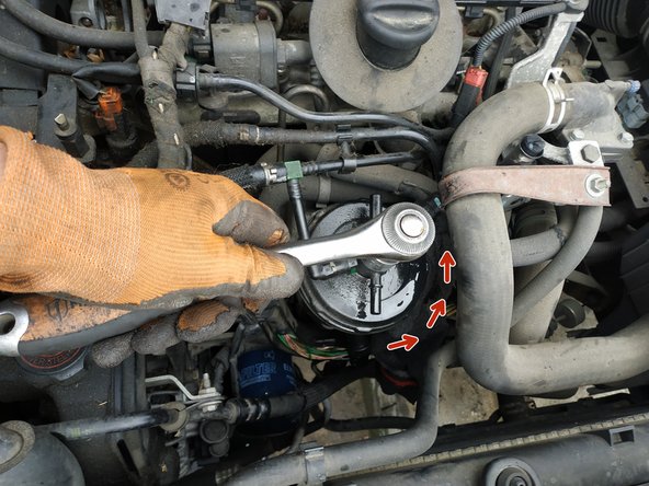 dévisser le couvercle d'1/4 de tour à l'aide d'une clé de 22mm, sens anti-horaire