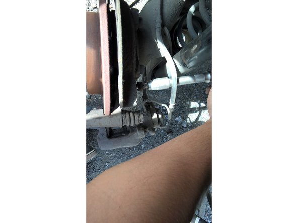 A l’aide de la clé à cliquet, de la rallonge et de la douille TORX 30 desserrer et retirer les deux vis qui maintiennent le support d’étrier au support de fusée.