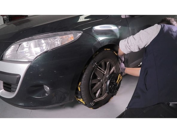 Vérifier que la poignée de tension soit bien sur la position ouverte pour finir de positionner la bande roulement sur le haut du pneu et tout autour de la roue.