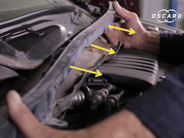 Retirer la  traverse en plastique en commençant par le coté conducteur puis appuyer sur la languette pour dégager le coté passager