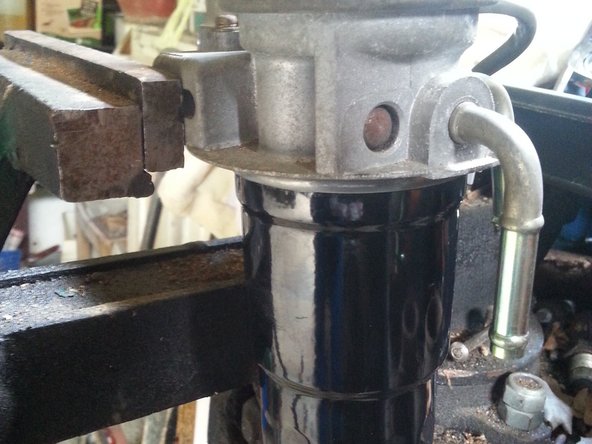 Repositionner le support de filtre sur la nouvelle cartouche et serrer à la main