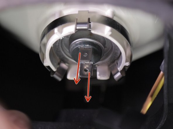 Pour retirer l'ampoule de son emplacement, tirer vers le bas sur les deux connecteurs