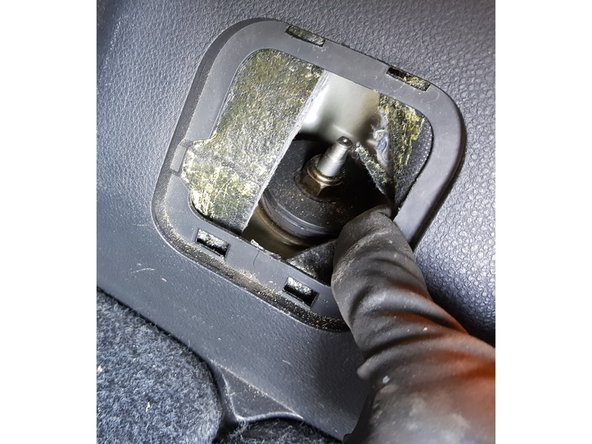 Vous apercevrez derrière l'isolant la tige de l'amortisseur.