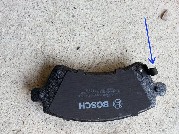 reposer les nouvelles plaquettes, la plaquette avec le témoin d'usure (flèche bleu ) va derrière