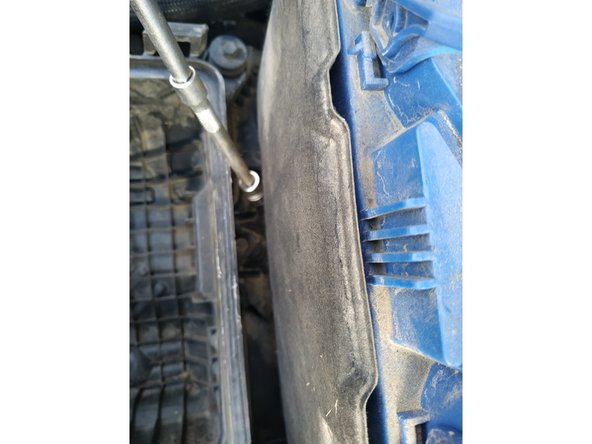 Remettre l'isolant autour de la batterie et positionner la. Mettre la patte de fixation en place et la serrer avec la clef à cliquet de 10 mm équipée d'une rallonge.