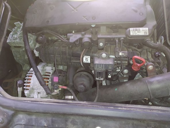 Repérer la &quot;cloche&quot; du filtre sur l'avant du moteur en dessous du cache ( à retirer en tirant dessus)