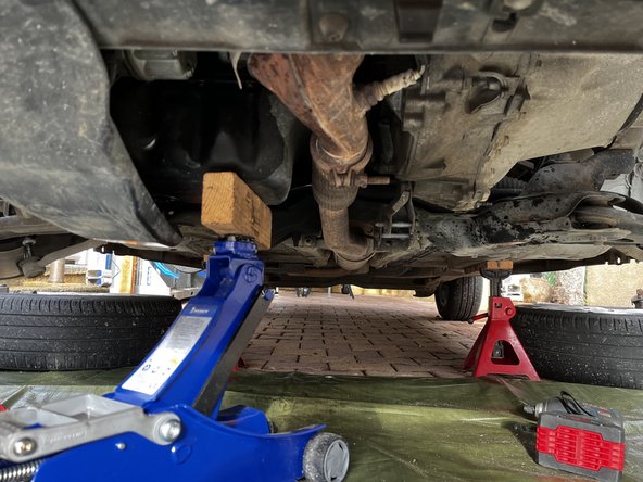 Sous le véhicule, a l'aide d'un cric et d'une cale en bois, se mettre en appui sous le carter d'huile.