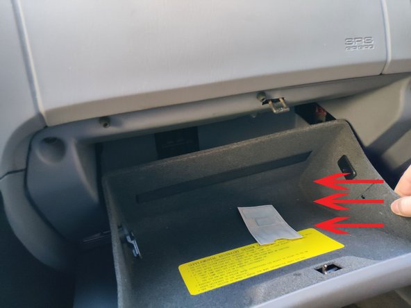 Remettre en place la boîte à gants en exerçant une pression vers  l'intérieur du côté gauche et du côté droit.