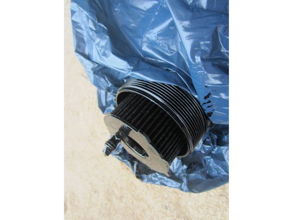 Prendre un sac poubelle par exemple pour récupérer la cloche et l'ancien filtre