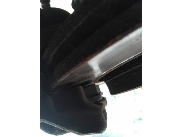 Détacher l'étrier de la suspension, repositionner le à son emplacement d'origine. Les plaquettes ne touchent pas le disque.