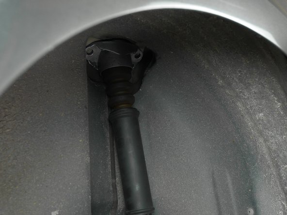 Réinsérer la tête d'amortisseur dans son emplacement, dans le passage de roue